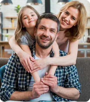 Eine glückliche Familie sitzt auf einer Couch in ihrem neuen Zuhause